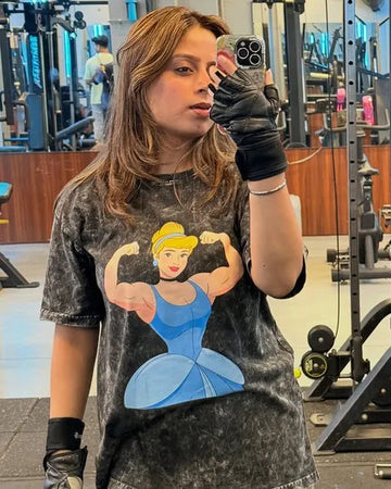 Person wearing a manmaker t-shirt with a graphic design of a cinderella in a gym